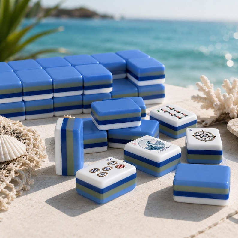 May include: A set of blue, green, and white mahjong tiles with some featuring nautical designs like a compass, a wave, and the text NORTH. The tiles are arranged in stacks and scattered on a surface, showcasing a layered color block design.