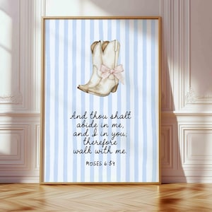 May include: A framed print featuring a watercolor illustration of a white cowboy boot with a pink bow, set against a light blue and white striped background. The text reads "And thou shalt abide in me, and I in you; therefore walk with me. MOSES 6:34."