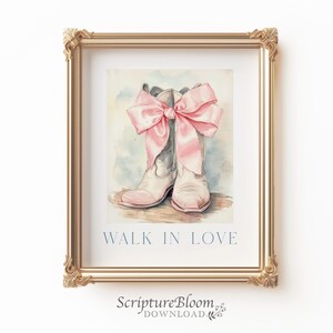 May include: A pair of white cowboy boots with a large pink bow tied around the tops. The boots are on a light brown background. The text "WALK IN LOVE" is printed below the boots.