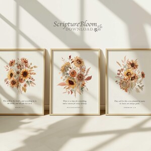 May include: Three framed art prints with watercolour sunflower bouquets in warm tones. Each print has a gold frame and a different Bible verse at the bottom. The text "ScriptureBloom DOWNLOAD" is at the top.