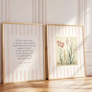 May include: Two framed prints with gold trim. One features text from Micah 6:8 on a pink and white striped background. The other print displays a botanical illustration of pink and yellow flowers with green stems, also on a striped background.
