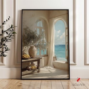 Könnte beinhalten: Ein rechteckiger gerahmter Wandkunstdruck mit einer Küstenszene, die ein offenes Bogenfenster mit Blick auf das blaue Meer zeigt. Auf einem Holztisch stehen eine Keramikvase mit Grünpflanzen und eine Schale mit gelben Früchten.