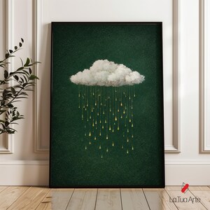Puede incluir: Impresión artística enmarcada que presenta una nube blanca con lluvia dorada sobre un fondo verde oscuro texturizado. La obra de arte está en un marco negro y se exhibe sobre un suelo de madera. La firma del artista, "La Tua Arte", es visible en la esquina inferior derecha.