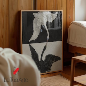 Puede incluir: Una lámina de arte rectangular enmarcada que muestra un cisne blanco sobre fondo negro y un cisne negro sobre fondo blanco, con sus picos tocándose en el centro. La lámina está en un marco de madera clara y muestra el texto La Tua Arte.