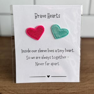 May include: A handmade wooden sign with the text "Welcome" in a playful font. The sign is painted white with a distressed finish, and features a small, decorative heart. Dimensions are approximately 12 inches wide and 6 inches high.