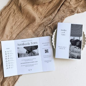 Könnte beinhalten: Eine weiße Hochzeitseinladung mit einem Schwarzweißfoto eines Paares. Die Einladung enthält die Namen Annika und Tom, das Hochzeitsdatum und den Ort der Hochzeit. Die Einladung enthält auch einen QR-Code.