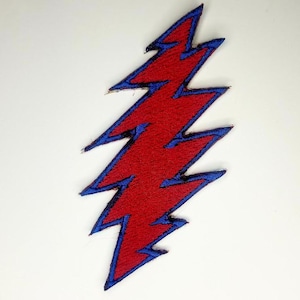 May include: Red and blue lightning bolt patch. The patch is made of embroidered fabric and has a blue outline.