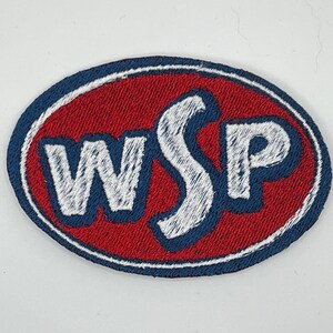 May include: Oval-shaped embroidered patch with the letters "WSP" in white, outlined in blue, set against a red background. The patch has a blue border and is likely designed for application on clothing or accessories.