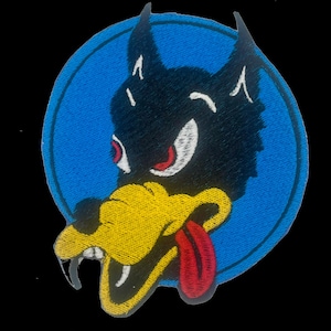 May include: Embroidered patch featuring a snarling wolf head with a red tongue and eyes, set against a blue circular background. The wolf is black with yellow and white accents, on a black background.