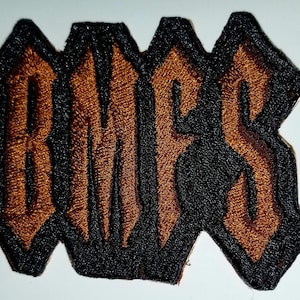 May include: Brown embroidered patch with the word "RATS" in black outlined letters.