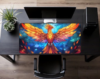May include: A vibrant, stained-glass style mousepad featuring a phoenix with outstretched wings. The design incorporates shades of orange, yellow, and blue, with a detailed, artistic rendering. The mousepad is rectangular and sits on a black desk.