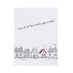 Pode incluir: Um têxtil branco com uma ilustração desenhada à mão de várias casas. As casas têm contornos pretos e diferentes estilos de telhado, com um telhado vermelho. O texto "Out of all the roofs one is mine" está escrito no topo.