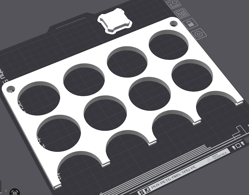 Puede incluir: Una bandeja rectangular blanca impresa en 3D con once recortes circulares y dos recortes semicirculares a lo largo de un borde. La bandeja tiene un peque&ntilde;o recorte cuadrado en la esquina superior derecha, sobre un fondo gris oscuro.