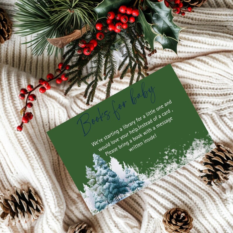 May include: A green card with the text "Books for baby" and a message requesting books instead of cards for a baby. The card features a winter forest scene and is surrounded by pinecones and greenery.