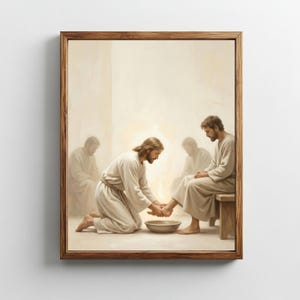 Puede incluir: Una obra de arte religiosa enmarcada representa una escena bíblica. Una figura con túnicas blancas se arrodilla, lavando los pies de otra figura. Otras dos figuras están sentadas y dos más están en el fondo. La obra de arte está en un marco de madera.