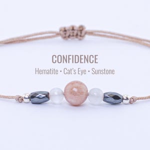 Puede incluir: Una taza de cerámica blanca con un asa negra y el texto "But First, Coffee" en un estilo manuscrito. La taza está sobre una superficie blanca. La taza mide aproximadamente 10 cm de alto.