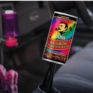 May include: A can of BOSS Rainbow Mountain Blend coffee. The can has a vibrant design with the BOSS logo and "RAINBOW MOUNTAIN BLEND" text. It also displays "W-ESPRESSO" and "SUNTORY". The can is cylindrical and likely contains coffee.
