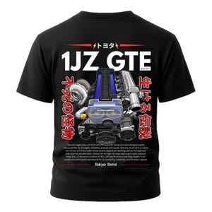 Könnte beinhalten: Schwarzes T-Shirt mit einer detaillierten Grafik eines 1JZ GTE Motors mit blauen und silbernen Komponenten. Der Text "1JZ GTE" ist prominent über der Motorillustration platziert, mit japanischem Text an den Seiten. Das Shirt enthält auch den Text "Tokyo Toms".