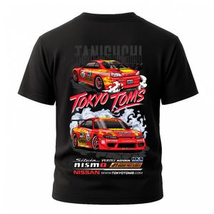 May include: Black t-shirt featuring a graphic of two red and yellow race cars with the text "TOKYO TOMS" and "NISSAN". The design includes the text "TANIQUCHI", "Silvia", "VERTEX ADVAN", and "HKS".