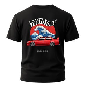 May include: Black t-shirt featuring a red car graphic with the text "TOKYO TOMS" above a wave and mountain design. The text "EVO 4-5-6" is below the car.