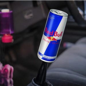 May include: A Red Bull energy drink can with a blue and white design. The can features the Red Bull logo and the words "ENERGY DRINK". The can is 250 ml.