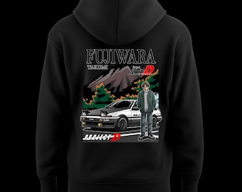 Può includere: Felpa con cappuccio nera con grafica di un'auto bianca e nera, una persona e il testo "FUJIWARA TAKUMI" e "PROJECT-D". Il design include un paesaggio montano e testo giapponese.