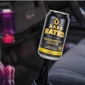 May include: A black and yellow Hard Rated Alcoholic Lemon beverage can. The can features the text "HARD RATED" in yellow, and "ALCOHOLIC LEMON" below. It also states "MADE WITH CRUSHED LEMONS" and "4.5%" alcohol content. The can is 375 ml.