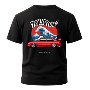 May include: Black t-shirt featuring a red car graphic with the text "EVO 1-2-3" below. The design includes a wave, Mount Fuji, and the words "TOKYO TOMS" in a stylized font. The shirt is short-sleeved.