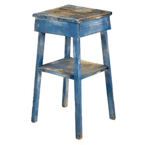 May include: A weathered, blue wooden side table with a shelf. The table has a rectangular top and a lower shelf, supported by four legs. The blue paint is distressed, revealing the wood grain beneath. The table is likely vintage or antique.