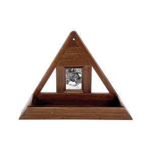 May include: A triangular wooden shelf with a small mirror inset. The shelf has a natural wood finish and is designed to be mounted on a wall.