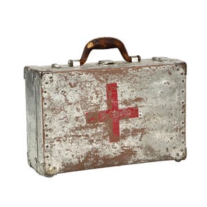 May include: Vintage metal first aid kit with a red cross emblem. The silver-toned case has a worn, distressed appearance with a brown leather handle. The corners are reinforced with metal and rivets.