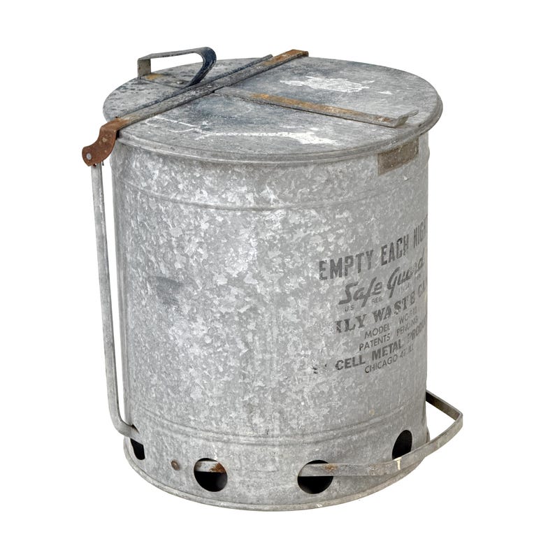 May include: A galvanized metal trash can with a lid and handle. The can has the text "EMPTY EACH" and "Safe Guard" printed on the side. It features a handle for carrying and air holes near the bottom. The can is cylindrical and has a distressed finish.