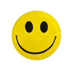 May include: A yellow smiley face with black eyes and a curved black mouth. The circular design has a textured appearance and is set against a white background. The smiley face is a classic symbol of happiness.