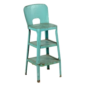 May include: A vintage-style metal step stool chair painted in a distressed turquoise finish. This piece features a high backrest with a cutout handle, a flat seat, and two lower steps, all showing visible signs of wear and rust on the edges.