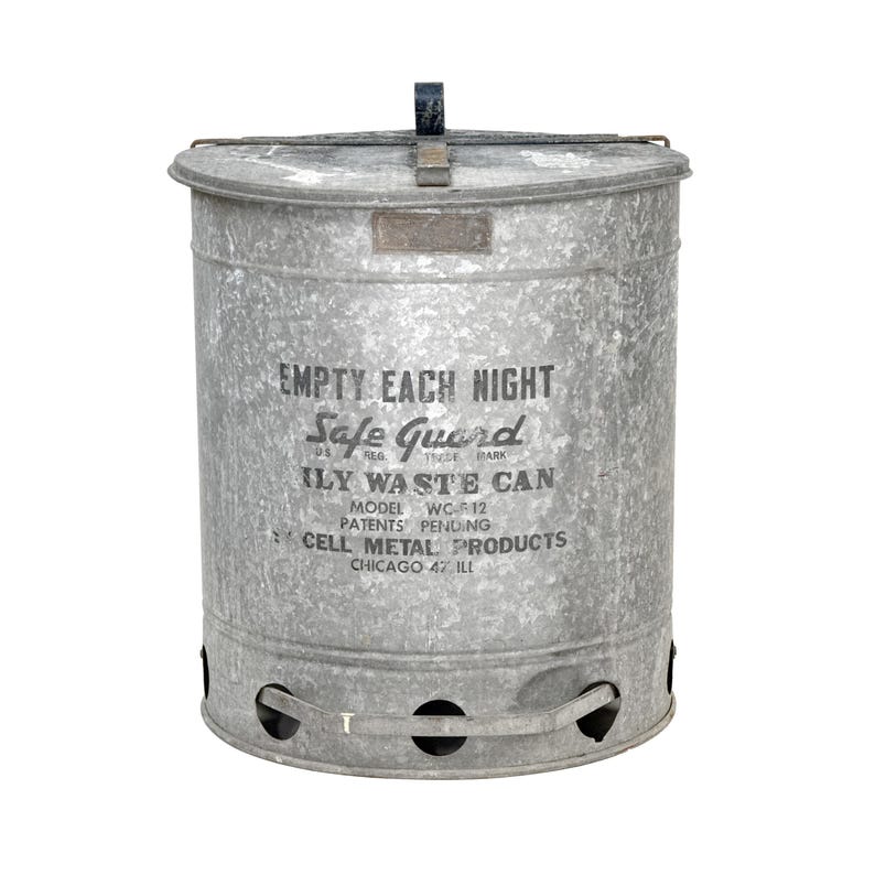 May include: A galvanized metal Safe Guard ily waste can with a lid and handle. The can has the text "EMPTY EACH NIGHT" and "ILY WASTE CAN" printed on the front. Model WC-F12. Cell Metal Products, Chicago 47, ILL.