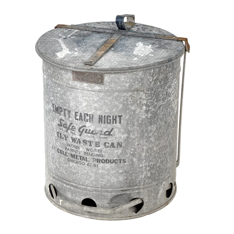 May include: A vintage galvanized steel waste can with a lid and handle. The can features the text "EMPTY EACH NIGHT Safe Guard" and "ILY WASTE CAN". The model number is WC-12, and it was made by Cell Metal Products in Chicago, IL.