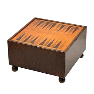 May include: A white ceramic mug with a black handle and the text "But First, Coffee" in a bold, black font. The mug is set against a blurred background, suggesting a cozy setting.