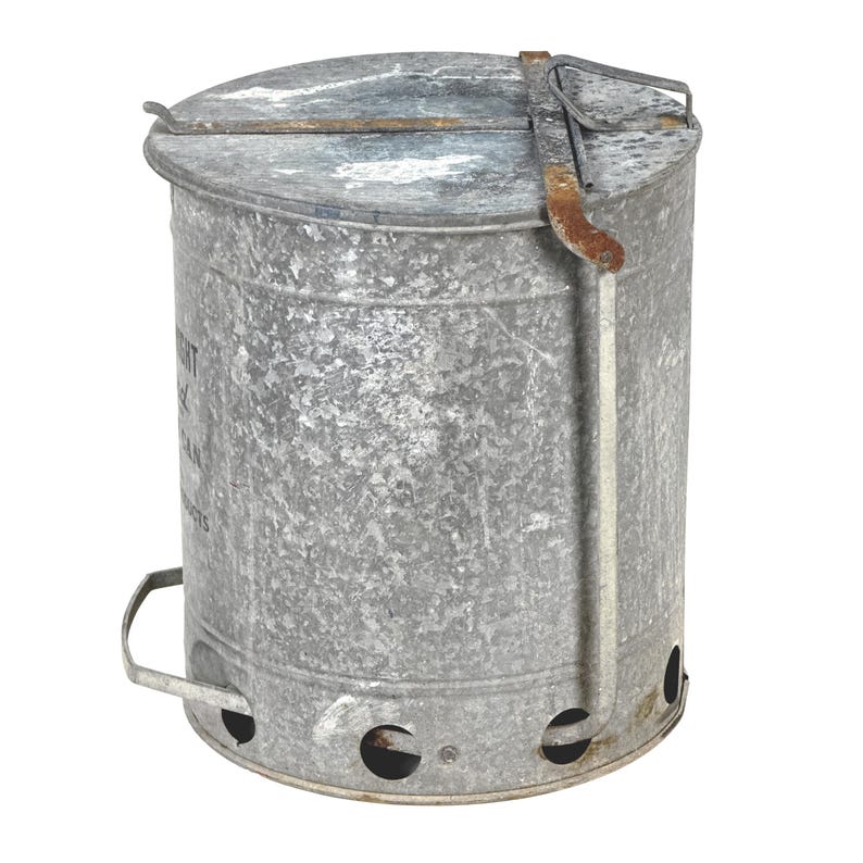 May include: A galvanized metal charcoal chimney with a lid and handle. The cylindrical container has air vents near the base and a hinged lid with a metal handle. The metal has a weathered appearance.