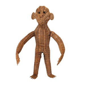 May include: A light brown monkey figurine crafted from woven wicker material. The figure features a rounded head with prominent ears, a textured body, long arms, and two legs. It has two small, dark, circular eyes set into the woven face.