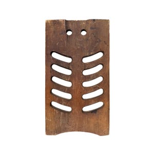 May include: A rectangular, wooden kitchen grater with a series of curved slots. The grater is made of dark brown wood and has two small holes at the top. The bottom of the grater has a curved edge.