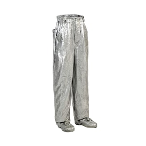 May include: Silver metallic pants with a textured surface. The pants have a high waist, belt loops, and pockets. The pants are paired with matching silver shoes. The overall style is futuristic and bold.