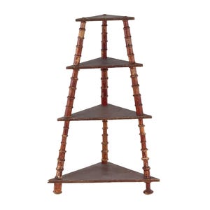May include: A four-tiered corner shelf with a bamboo-style design. The frame is painted a deep red with lighter accents, and the triangular shelves are a dark brown. The shelf is freestanding and suitable for displaying decorative items.