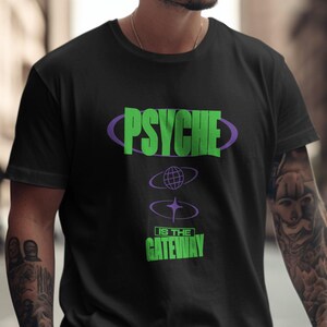 Könnte beinhalten: Schwarzes T-Shirt mit einem grünen und violetten Grafikdesign, auf dem "PSYCHE IS THE GATEWAY" steht.