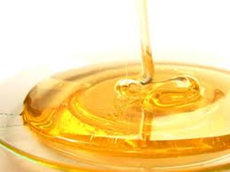 May include: Golden honey pouring into a clear glass dish, creating a swirling pattern.