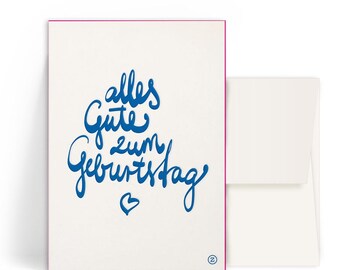 May include: A white card with a blue handwritten message that says "alles gute zum Geburtstag" with a small heart at the bottom.