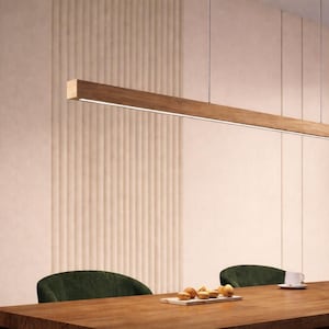 Puede incluir: Una lámpara colgante rectangular de madera suspendida sobre una mesa de comedor de madera. La luz tiene una tira de LED integrada. La habitación cuenta con una ventana grande, sillas verdes y una pared de color claro con paneles verticales. La mesa está puesta con tazas y pasteles.