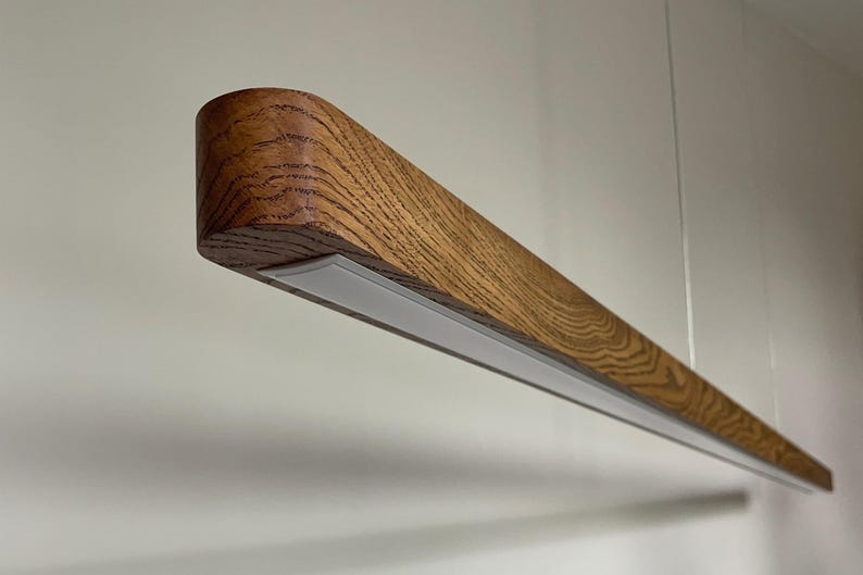 Minimalist wooden pendant lighting with LED, linear handmade chandelier suspended over dining room table, modern rustic ceiling light fixture made of natural wood.