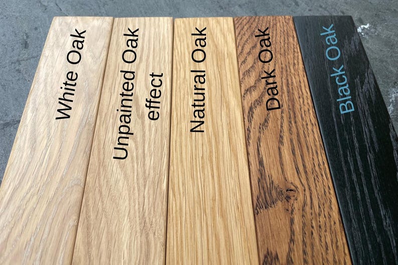 May include: A close-up of five wooden planks, each showcasing a different oak finish. The finishes include White Oak, Unpainted Oak effect, Natural Oak, Dark Oak, and Black Oak, with the names of each finish printed on the planks.