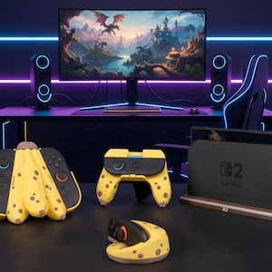 以下が含まれることがあります： ファンタジーの風景を表示する大きなモニターとスピーカーを備えたゲームセットアップ。黒いデスクには、Nintendo Switchコンソール、コントローラー、ゲーミングチェアが置かれています。コントローラーは、茶色の斑点のある黄色です。