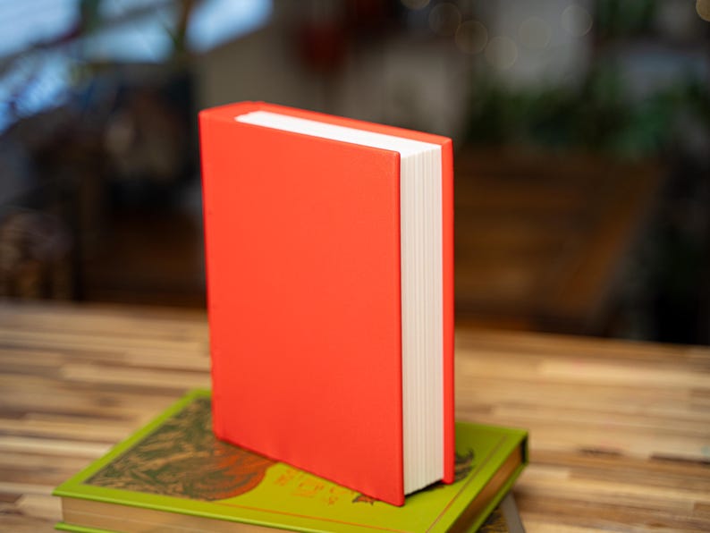May include: A white ceramic mug with a black handle and the text "But First, Coffee" in a black, bold font. The mug is sitting on a wooden surface. The mug is approximately 4 inches tall.